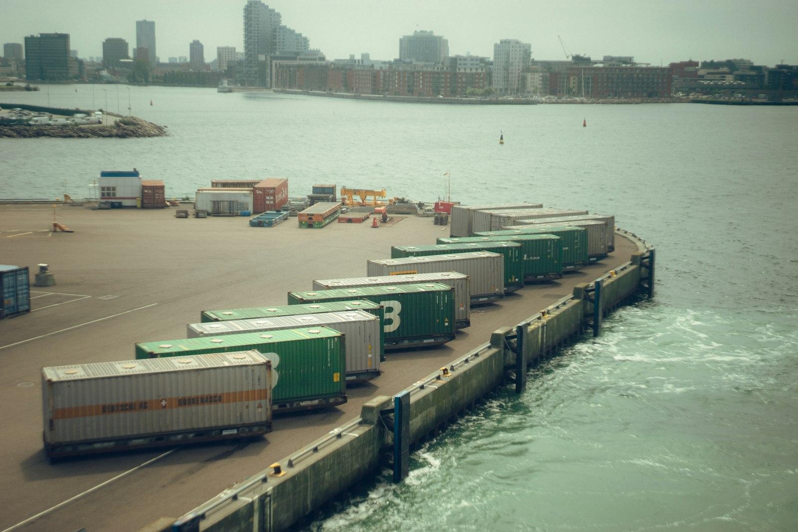 Rows of colorful shipping containers stacked densely at a maritime port terminal