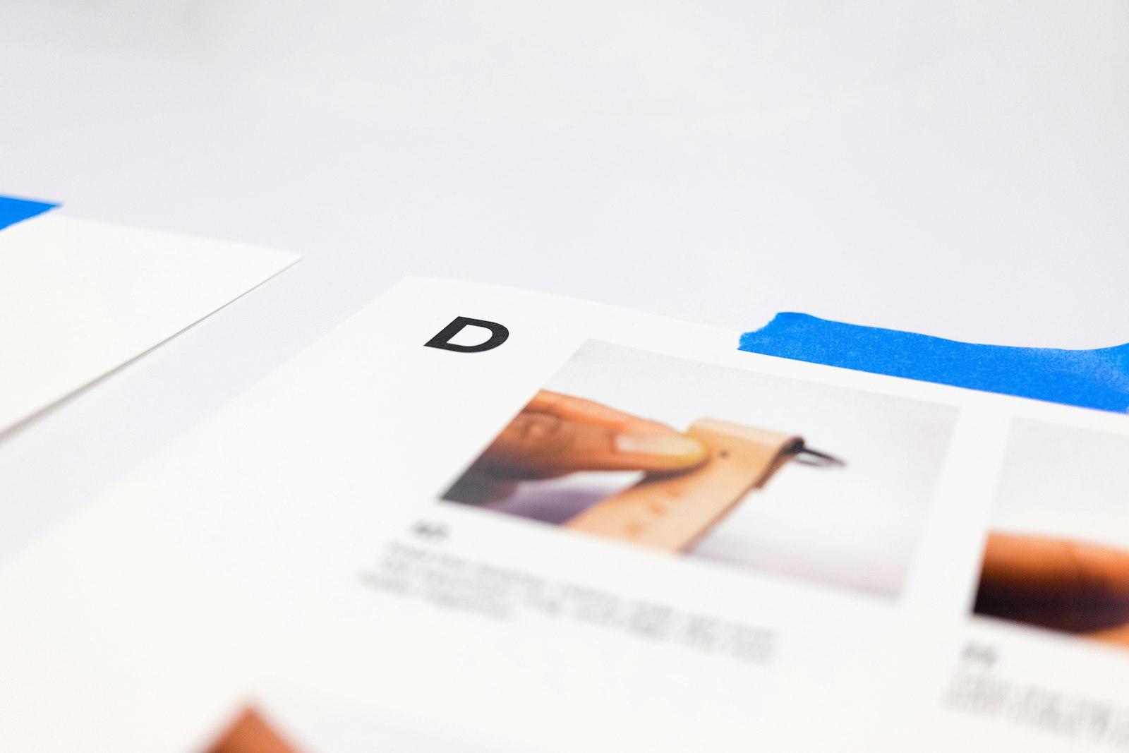 A pair of scissors cutting through white paper on a blue background