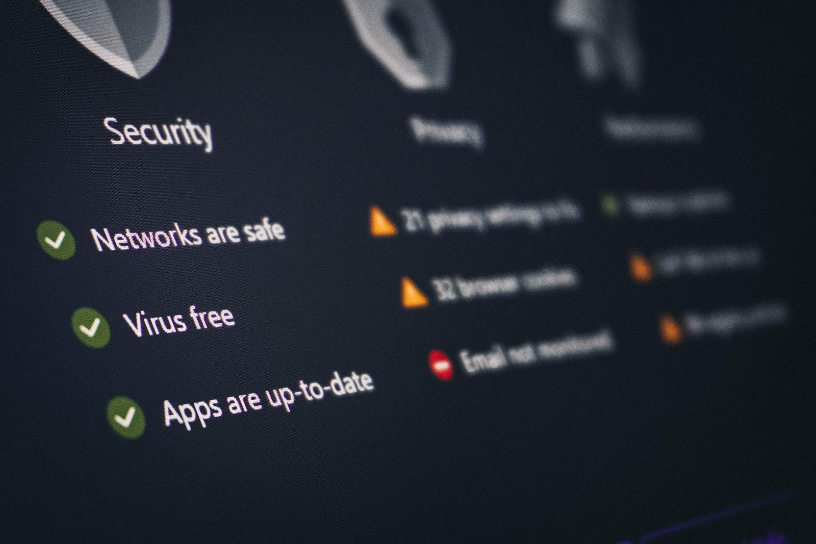 Close-up of a laptop screen displaying a security dashboard with warning alerts and status indicators for antivirus protection